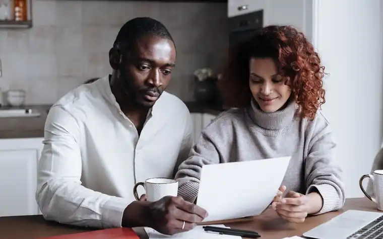 Couple reviewing an insurance policy document together at their kitchen table