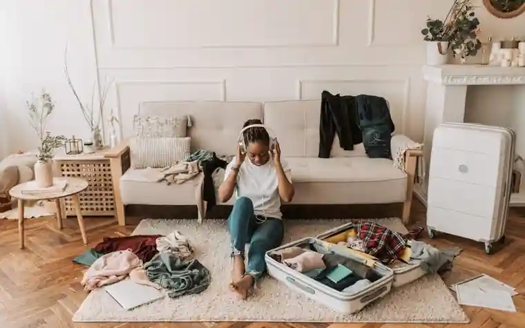 A woman packing a suitcase in her living room before a trip