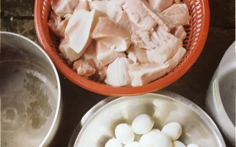 Top-down view of raw meat and boiled eggs portioned into bowls