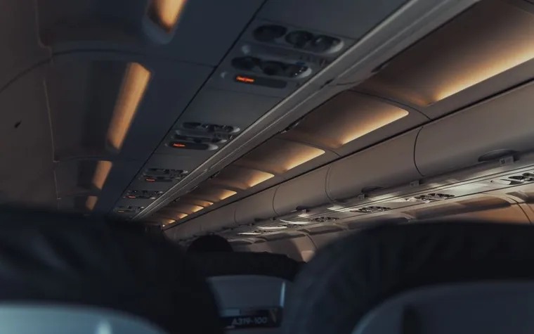 Interior of an airplane cabin with overhead panels and seats