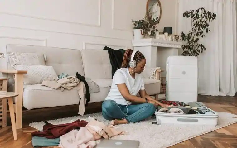 A person packing a suitcase in a living room before a trip