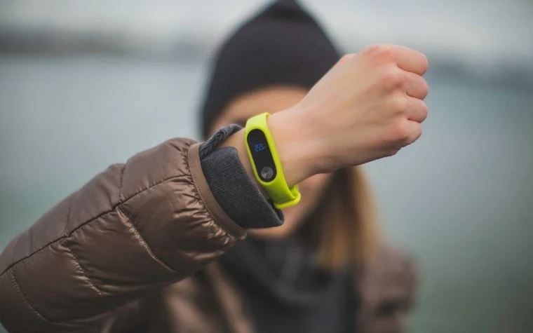 A close-up of a person holding a small tracker device