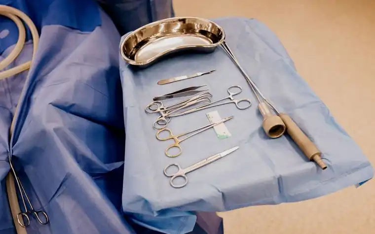 Sterile surgical instruments arranged on a blue drape tray