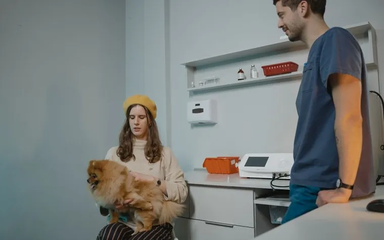 A dog owner talking with clinic staff at the front desk